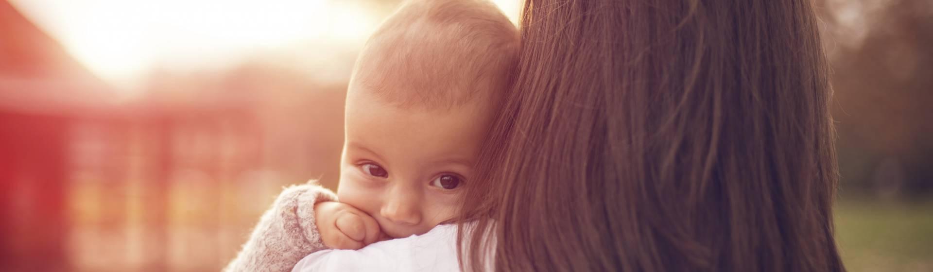 Jeune maman portant son enfant dans les bras prévoit de réaliser une simulation d'investissement sur l'assurance vie MULTÉO